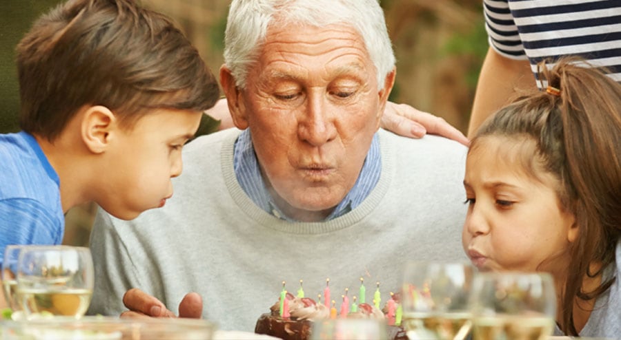 old man blowing out candles