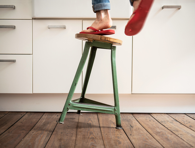 woman falling off a stool in the kitchen