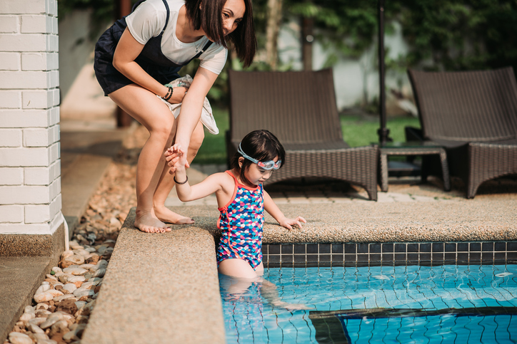 Practicing swimming skill at her own house swimming pool.