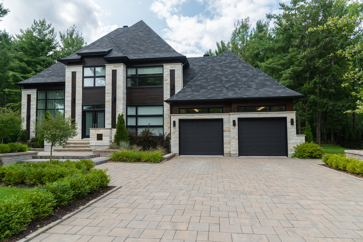 A brick house with dark trim and a big garage.