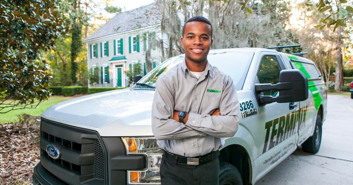 Terminix Exterminator standing in front of truck